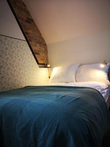 um quarto com uma cama grande e um cobertor azul em Sezonowa. Noclegi i chleb em Kłopotnica