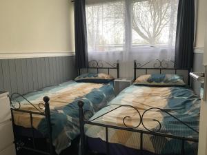 2 camas individuales en un dormitorio con ventana en 54 Belle Aire Hemsby en Hemsby