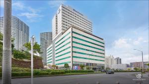 un gran edificio de oficinas con un coche conduciendo por una calle en Daiwa Roynet Hotel Naha Omoromachi en Naha