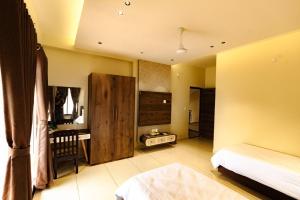 a bedroom with a bed and a crib in a room at IND57 in Siliguri