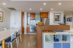 une cuisine et une salle à manger avec une table et des chaises dans l'établissement Casuarina Resort Style 3BR Apartment by uHoliday, à Casuarina