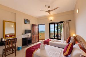 a hotel room with two beds and a mirror at ATREYA AYURVEDA BEACH RETREAT in Kovalam