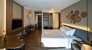 a hotel room with a white bed and a table at Sonaga Beach Resort & Villas Phu Quoc in Phu Quoc