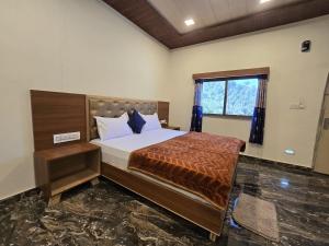 a bedroom with a bed and a window at Palm Valley Farmhouse in Mount Ābu