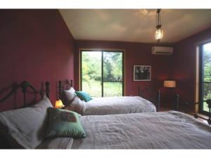 五島市にあるNonoya - Vacation STAY 78469vの赤い壁のベッドルーム(ベッド2台、窓付)