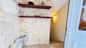 baño con pared de piedra y aseo en ALCAMAR, Penthouse for rent with beautiful views in Playa de San Juan! en Guía de Isora