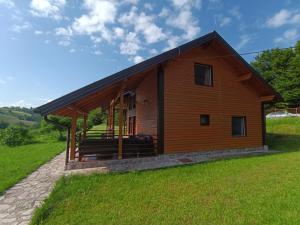 ein kleines Holzhaus auf einem grünen Feld in der Unterkunft Vikendica Jezerac in Banja Luka