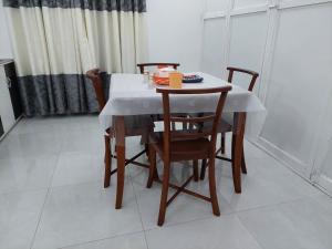 a dining room table with chairs and a white table cloth at Comfortable Stay in Colombo in Rajagiriya