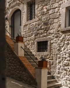 un edificio in pietra con scale e finestra di Abbergà a Santa Fiora