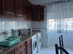 a kitchen with a washing machine and a microwave at Amazing Getaways in Amora