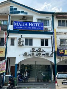 a building with a sign for a hotel at Maha Hotel in Puchong