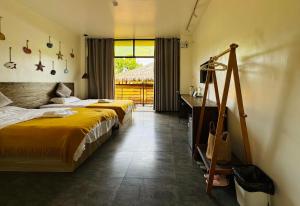 1 dormitorio con 2 camas, escritorio y ventana en 蓝色引力潜水度假村BLUE GRAVITY.WOW DIVING, en Panglao
