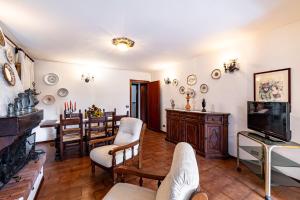 ein Wohnzimmer mit einem TV und einem Esszimmer in der Unterkunft Villino Carla Few KM From Lucca - Happy Rentals in Lucca
