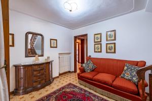 ein Wohnzimmer mit einem roten Sofa und einem Spiegel in der Unterkunft Villino Carla Few KM From Lucca - Happy Rentals in Lucca