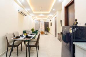 a kitchen and dining room with a table and chairs at Homlee-Vasundhara 2BHK Flat with Kitchen parking in Ghaziabad