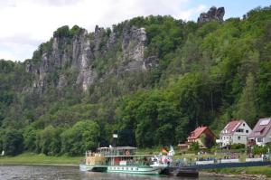 un barco en un río con una montaña en el fondo en Ferieneinrichtungen-Haus-am-Stein en Königstein an der Elbe