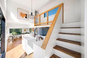 eine Küche und ein Wohnzimmer mit einer Treppe in einem Haus in der Unterkunft Tiny Home on 1 Acre Land in Picturesque Hawea Flat in Hawea Flat