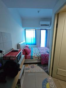 een kleine kamer met een bed en 2 ramen bij OSAKA RIVERVIEW in Tangerang