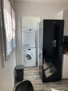 eine Küche mit einem Kühlschrank, einer Waschmaschine und einem Trockner in der Unterkunft Superbe chambre meublée avec sa propre salle de bains avec douche et wc privés in Vandoeuvre-lès-Nancy