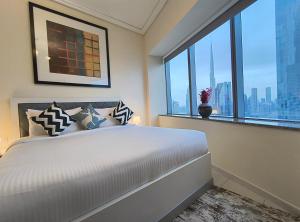 a bedroom with a large bed and a large window at Trinity Holiday Homes - Sheikh Zayed Road Near to Financial Center Metro Station in Dubai