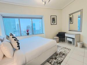 a bedroom with a bed and a desk and a window at Trinity Holiday Homes - Sheikh Zayed Road Near to Financial Center Metro Station in Dubai