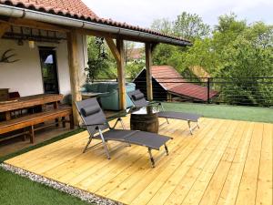 een houten terras met 2 stoelen en een tafel bij Papa Franks House in Ptuj