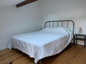 een slaapkamer met een wit bed met een metalen frame bij L'Atelier - Boulogne - Roland Garros, Parc des Princes, JO in Boulogne-Billancourt