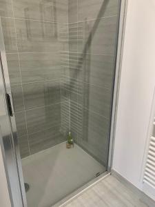 een douche met een glazen deur in de badkamer bij L'Atelier - Boulogne - Roland Garros, Parc des Princes, JO in Boulogne-Billancourt