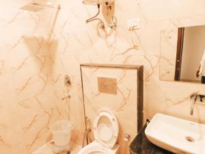 a bathroom with a white toilet and a sink at Hotel Tela Suite Plaza Near IGI Airport in New Delhi