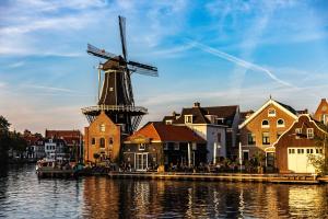 een windmolen in een stad naast een waterlichaam bij Amrâth Grand Hotel Frans Hals in Haarlem