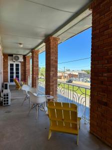 a patio with chairs and tables and a brick building at North Gregory Hotel in Winton