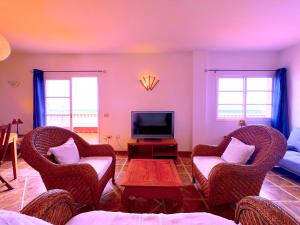 een woonkamer met twee stoelen en een televisie bij Tropicalidays Puerto Brava 2 Double Rooms in Puerto de la Cruz