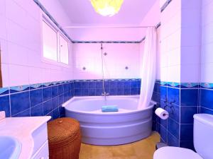 een blauw betegelde badkamer met een bad en een toilet bij Tropicalidays Puerto Brava 2 Double Rooms in Puerto de la Cruz +41 foto's