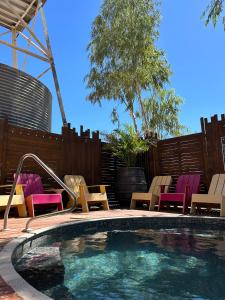 a swimming pool with colorful chairs and a fence at North Gregory Hotel in Winton