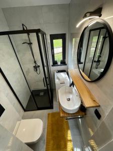 a bathroom with a sink and a mirror at Cudomki in Piecki
