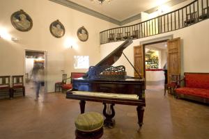 ein Wohnzimmer mit einem Klavier und einer Treppe in der Unterkunft Villa D'Arte Agri Resort in Pontassieve