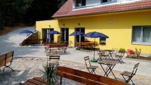 a patio with tables and chairs with blue umbrellas at Mezi Stromy in Brno