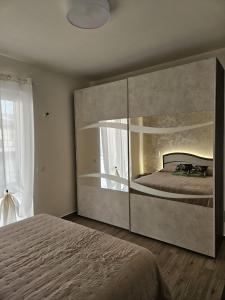 1 dormitorio con 1 cama grande y espejo grande en Apartments Miro' en Capo dʼOrlando