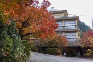 un edificio con árboles coloridos delante de él en Yunokaze HAZU, en Shinshiro