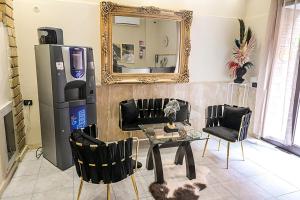 a living room with a table and a large mirror at Suisse hotel in Caserta
