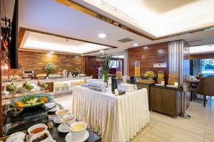 a restaurant with a buffet with food on a table at Winsuites Saigon in Ho Chi Minh City