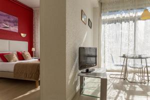 - une chambre avec un lit et une table avec une télévision dans l'établissement The Originals City, Hôtel Villancourt, Grenoble Sud (Inter-Hotel), à Le Pont-de-Claix