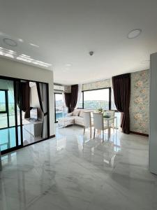 uma grande sala de estar com mesa e cadeiras em Arunsakhon luxury condo em Ban Khok Kham