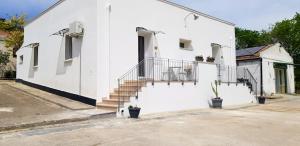 a white building with stairs on the side of it at Masseria Santa Maria in Gravina in Puglia