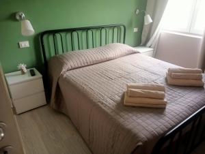 1 dormitorio con 1 cama con 2 toallas en Villa Rosetta wellnes relax, en Scrutto
