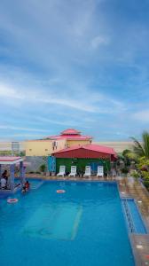 Una gran piscina con sillas y un edificio. en Sher Bengal Beach Resort, en Mandarmani