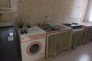a kitchen with a sink and a washing machine at OYO 93892 Homestay Koe Syariah in Purwokerto