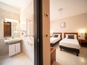 a hotel room with two beds and a bathroom at Hotel SAN PIO in San Giovanni Rotondo