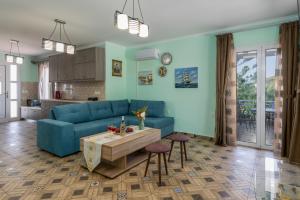 a living room with a blue couch and a table at Moulinos Cottages Kefalonia in Kardhakáta