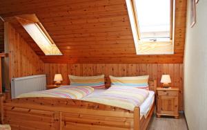 1 Schlafzimmer mit 2 Betten an einer Holzwand in der Unterkunft Ferienhof Serck - Galeriewohnung in Fehmarn